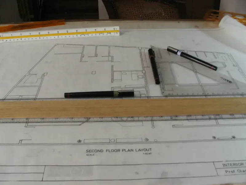 Second-floor plan laid out on a drawing board with a parallel rule, pens and a scale