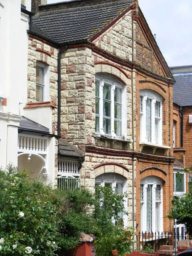 Flat-fronted Victorian house of 1898 in brick and stone with arched sash windows and a bay