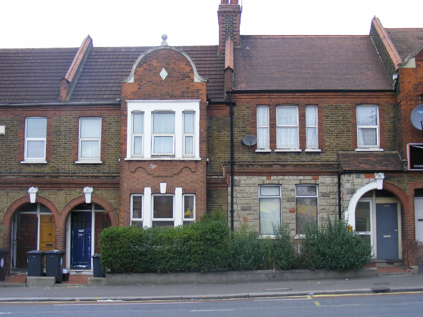 Victorian brick terraced houses with bay windows and hedges on a street in Waltham Forest, London