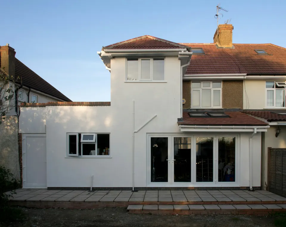 Finished white-rendered rear house extension with large glazed doors