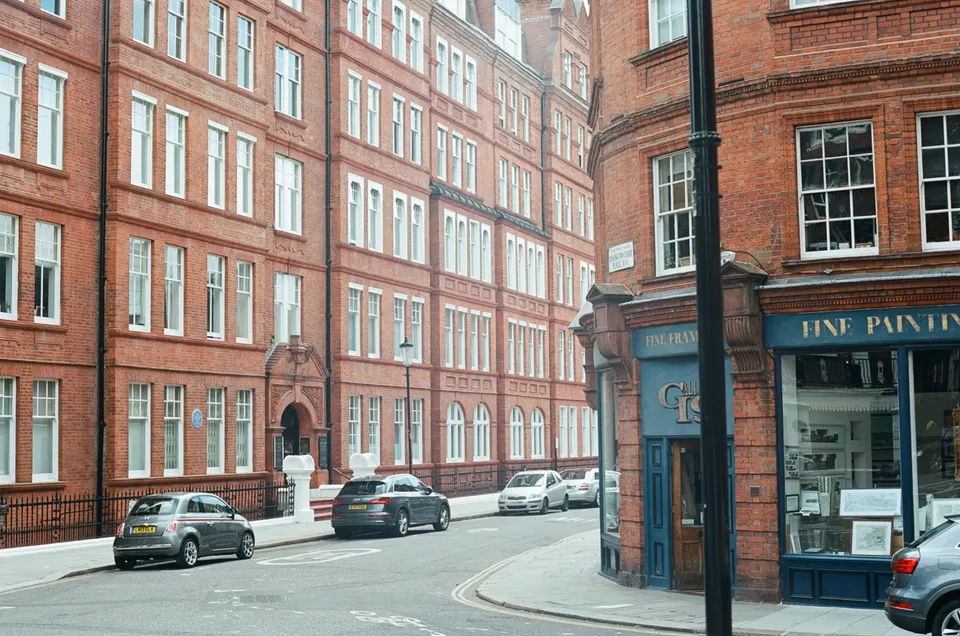 Red-brick mansion blocks and shopfronts on a street corner